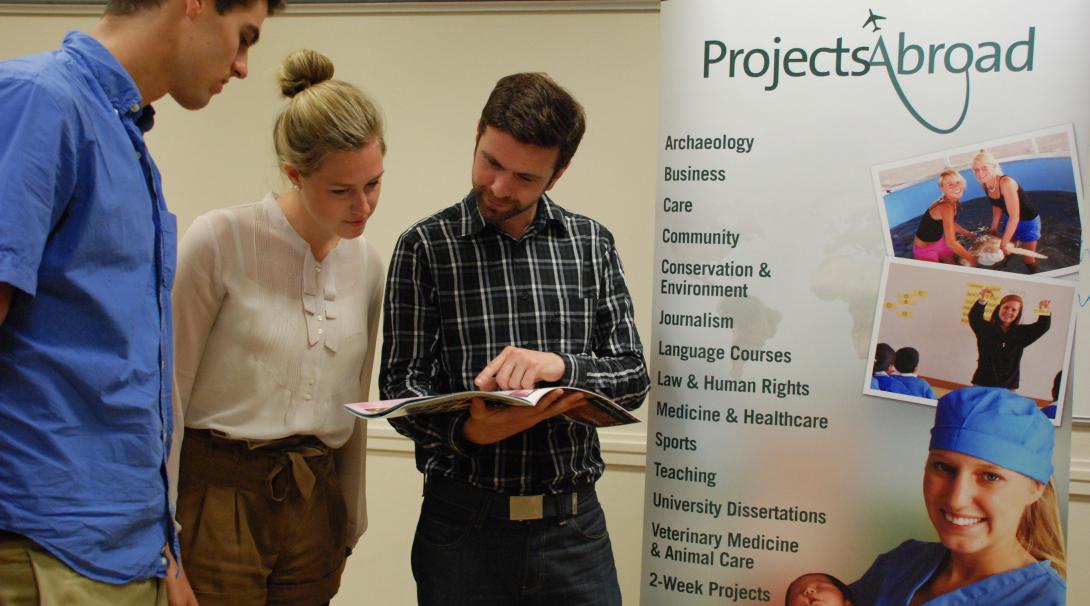 Projects Abroad staff talk to potential volunteers during an information event in the UK. Leads have the volunteer projects and internships explained during an event.